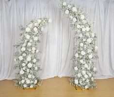 two white flowers are arranged in the shape of an i - letter on top of each other