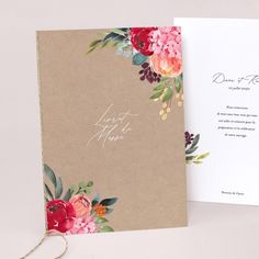 an open wedding card with flowers on it