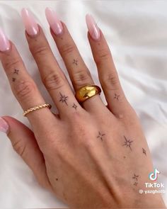 a woman's hand with pink manicures and stars on her ring finger