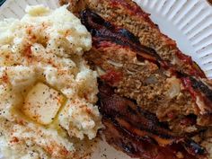 a white plate topped with meat and mashed potatoes