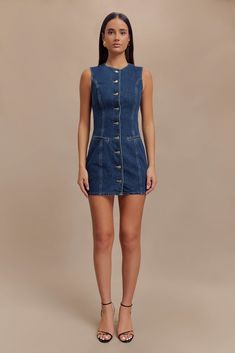 Denim devotion. The JANE Button Down Denim Mini Dress is a stylish and versatile addition to any wardrobe. Featuring a round neckline and a centre front button closure, this sleeveless dress offers a clean and classic look. The front mock pockets and princess seams add subtle detailing, enhancing the dress's tailored fit. With its mini length, the Jane dress is perfect for both casual outings and dressier occasions, combining the timeless appeal of denim with modern design. Button Up Dress Outfit, Denim Dress Outfit, Denim Button Up Dress, Jane Dress, Princess Seams, Denim Mini Dress, Button Up Dress, Denim Mini, Tee Dress