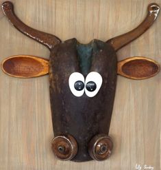 a cow's head with eyes and horns painted on the side, sitting on a wooden surface