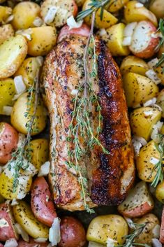 roasting pork with potatoes and rosemary garnish