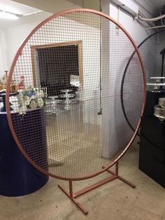 a large round mirror sitting on top of a metal stand