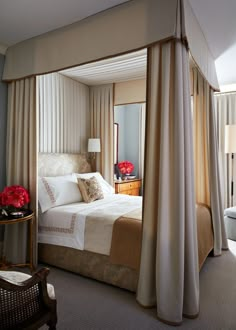 a large bed sitting in a bedroom next to a window with curtains on top of it