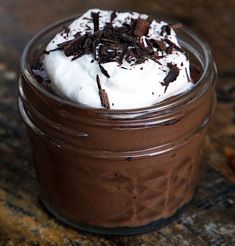 a glass jar filled with chocolate pudding and whipped cream