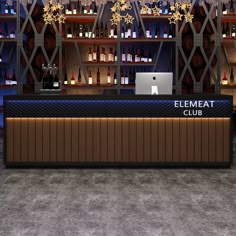 an empty bar with bottles on the shelves and a laptop computer in front of it