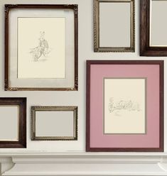 several framed pictures hang on the wall above a fireplace