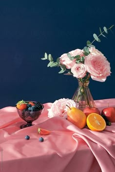 an arrangement of fruit and flowers in a vase on a pink cloth by jodi lenski for stocksy