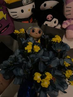 a bunch of stuffed animals sitting on top of a table next to a bouquet of flowers