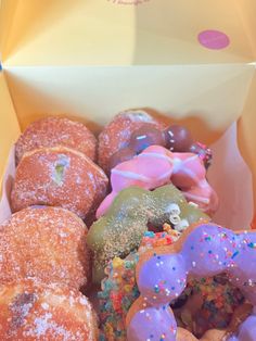 a box filled with lots of different types of doughnuts covered in sprinkles