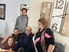 a group of people standing around a table with food on it and plates in front of them