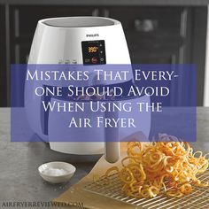 an air fryer sitting on top of a counter next to some noodles and sauce