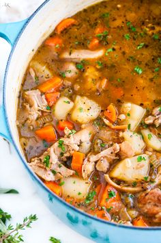 a blue pot filled with meat and vegetable soup