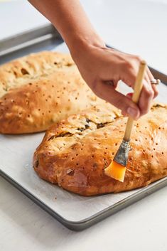 a person using a brush to spread butter on some bread