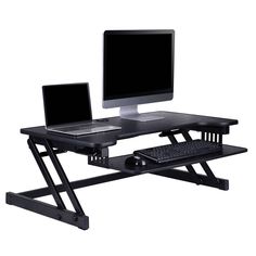 a computer desk with two computers on top of it and a keyboard in front of the monitor