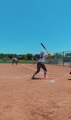 a baseball player holding a bat on top of a field in front of home plate