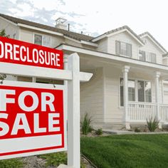 a red for sale sign sitting in front of a white house with the words power of sale written on it