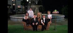 a group of people sitting on top of a couch in front of a fountain