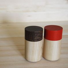 two small wooden containers sitting on top of a wooden table next to eachother