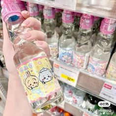 a woman holding a bottle of water in front of a shelf with bottles on it