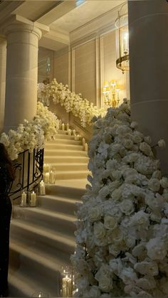 the stairs are lined with white flowers and candles