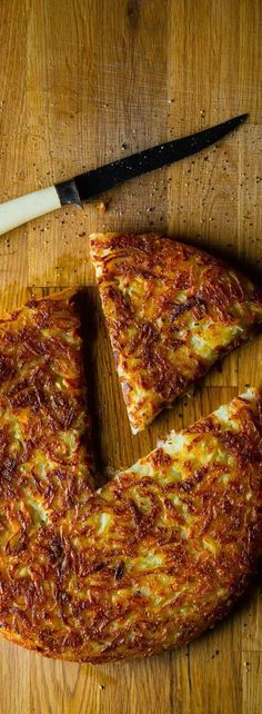 two slices of pizza sitting on top of a wooden cutting board next to a knife