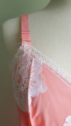 What a peach! 🍑 This darling vintage slip features a fresh apricot-pink hue; crisp white floral lace trim; a graceful, gathered bustline; and a double-lined front panel. Excellent condition. Size: 34 Era: 1960s Label: none, has a blue and white ILGWU tag Material: 100 percent nylon Length: 37.5 inches ♡ more rare and beautiful treasures on Instagram at provenance_vintage Pink Lace Nightgown For Summer, Pink Lace Summer Nightgown, Feminine Delicate Lace Slip Dress For Wedding Night, Sleeveless Sleepwear With Lace Trim For Wedding, Feminine Wedding Night Slip Dress With Lace Trim, Sleeveless Wedding Sleepwear With Lace Trim, Pink Lace Trim Slip Dress For Daywear, Pink Fitted Slip Dress With Delicate Straps, Feminine Delicate Lace Camisole For Wedding Night