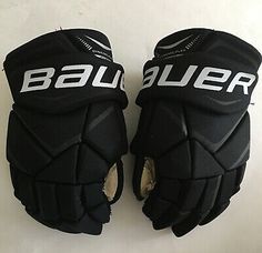 two black hockey gloves with white lettering on them