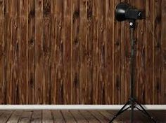 an empty room with a wooden wall behind a tripod and light on the floor