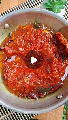 a bowl filled with sauce on top of a wooden table