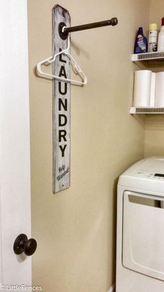 a laundry sign hanging on the wall next to a washer and dryer in a bathroom