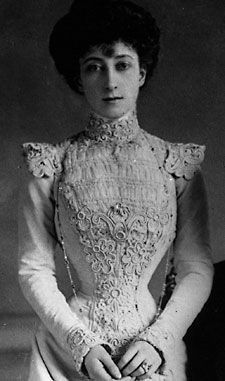 an old black and white photo of a woman wearing a dress with lace on it