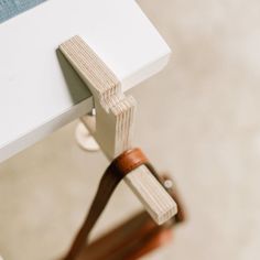 a close up view of a white table with wood handles on it's legs