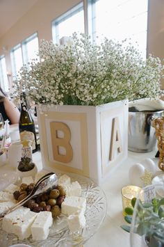 the table is set with cheese, crackers and flowers in vases on it