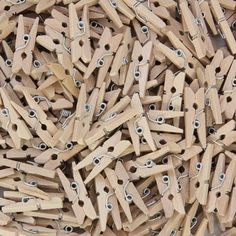 a pile of wooden clothes pegs with eye holes and clips attached to the ends