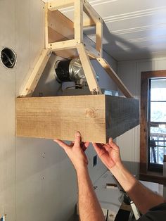 a man is working on a piece of wood that has been built into the wall