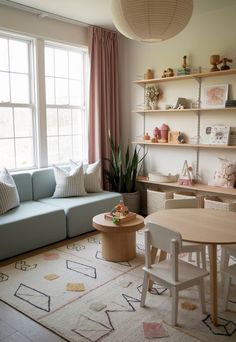 a living room filled with furniture next to a large window covered in pink drapes