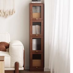 a living room with a white couch and tall wooden shelf