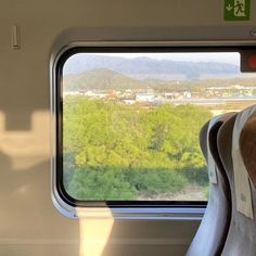 the view from inside a train looking out at trees and mountains outside it's window