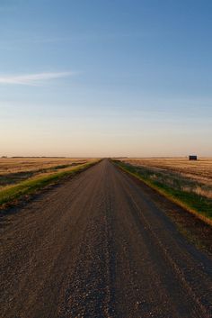 an empty dirt road in the middle of nowhere