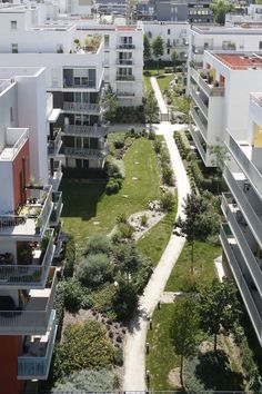 an aerial view of some apartment buildings and a path leading to the parking garages