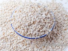 a bowl full of sunflower seeds sitting on top of a white tablecloth with blue trim