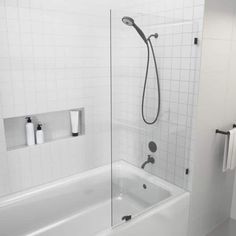 a white bathroom with a glass shower door, toilet and bathtub next to each other