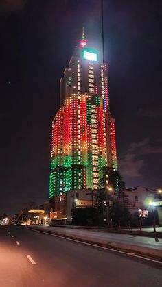 a very tall building with lights on it's sides at night in the city