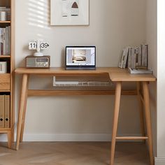 a laptop computer sitting on top of a wooden desk next to a book shelf filled with books