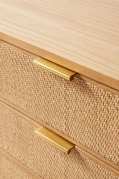 a close up of a wooden dresser with two drawers and brass pulls on the handles