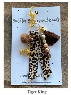 a keychain with a leopard print pattern and tassels attached to it