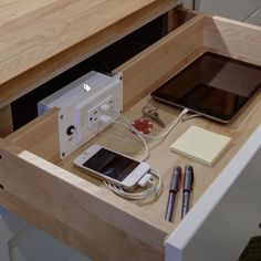 an electronic device is plugged into the charging station on top of a wooden desk