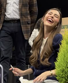 a woman laughing while sitting next to a man